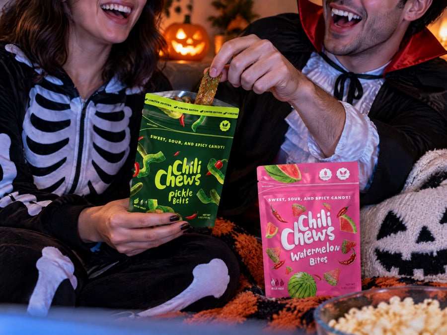 Friends in costumes sharing Pickle Belts on horror movie night